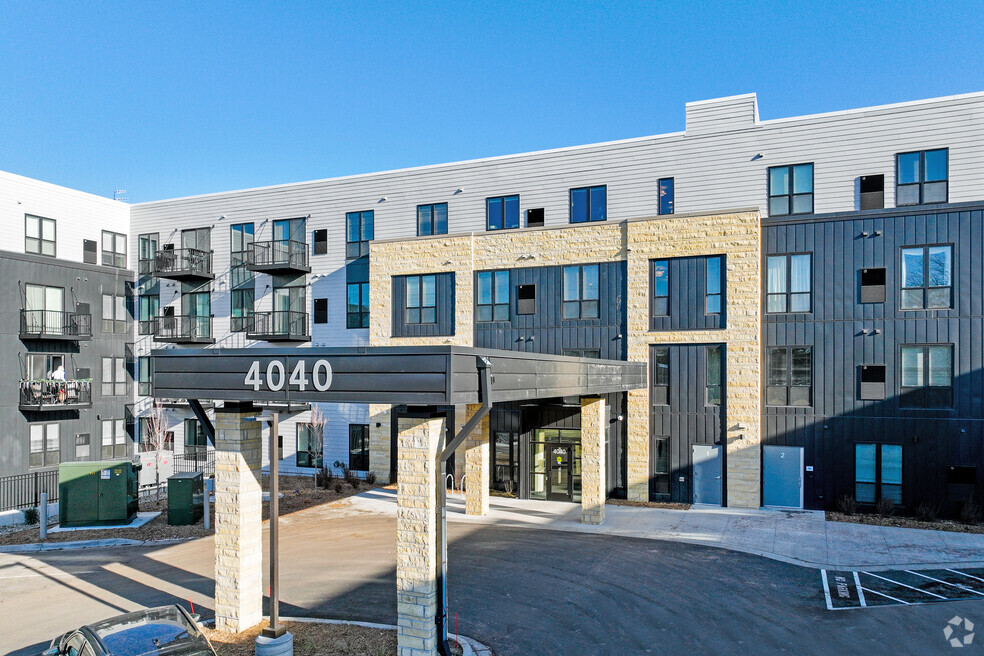 An image of a new apartment building labeled 4040 with a traffic circle entrance.