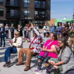 A crowd of residents and community members gathers at Wirth on the Woods