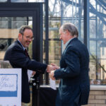 Steve Minn shakes hands with Metropolitan Council Chair Charlie Zelle